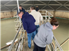 Attendees walk onto a platform at the wastewater treatment plant. 