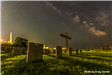 Cross and markers in front of a starry night sky. 
