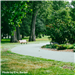 A bench beside a path at Sertoma Park. 
