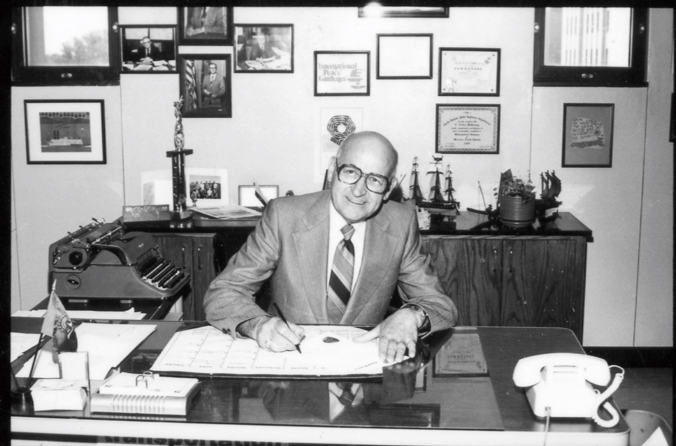 Mayor Eugene "Bus" Leary signs documents at his desk. 