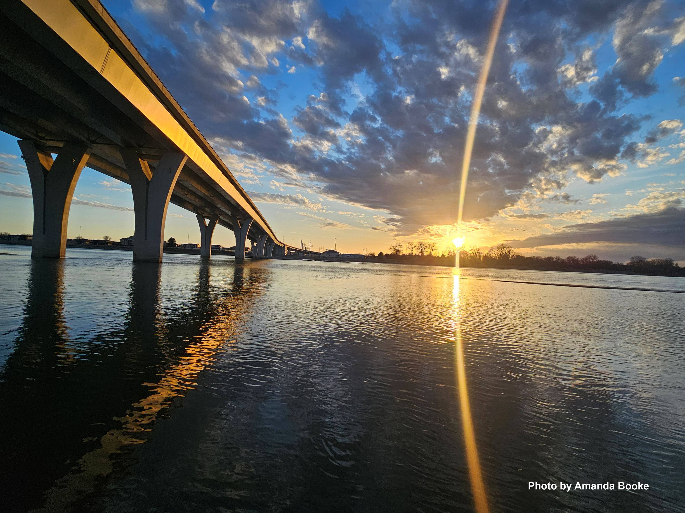 Bridge crossing the Missouri River in front of sunset. 
