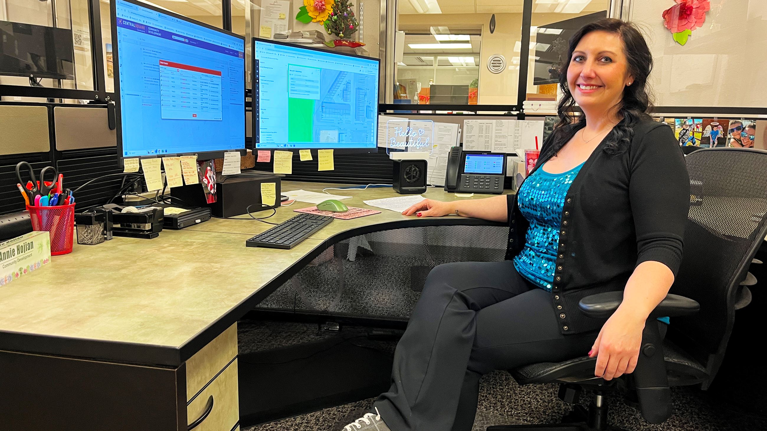 A woman seated at a desk in front of a computer. 