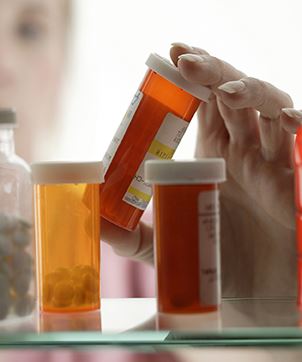 Person taking medication from medicine cabinet JPEG