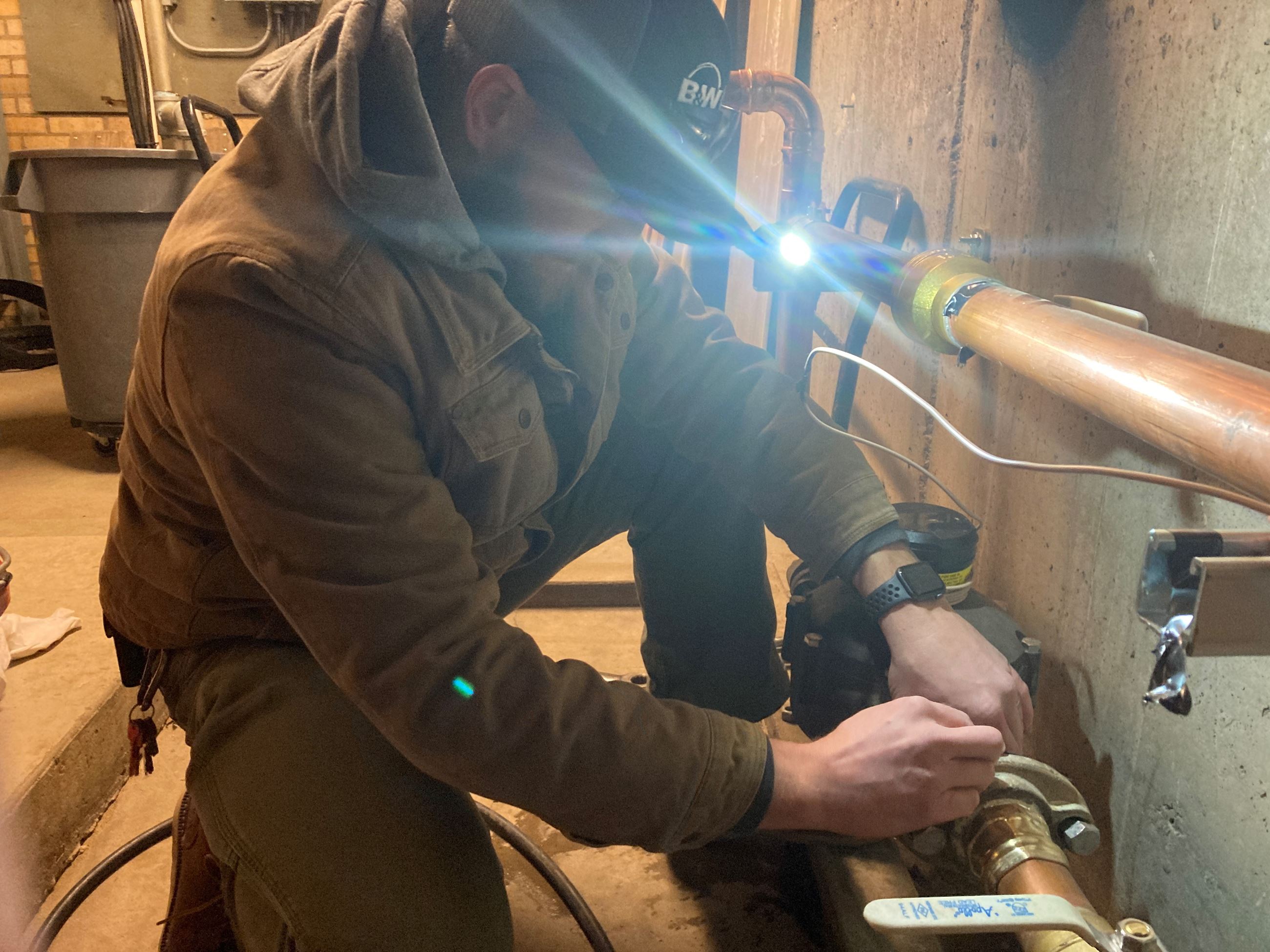 Customer Service Field Lead Mike Fischer reattaches a water meter to a service line. 