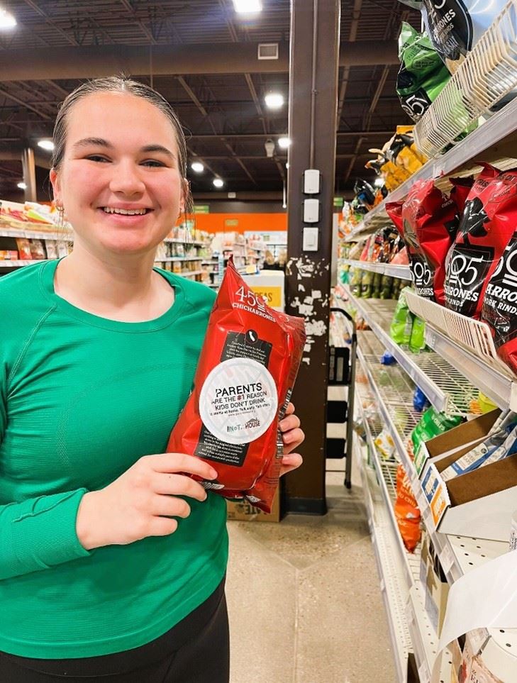 BHS student Raya Wood placing educational stickers on items at Natural Grocers Grocery Store. 