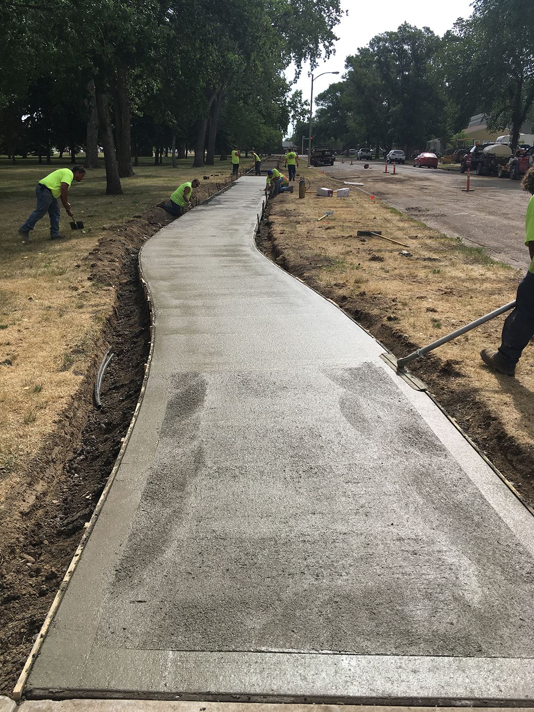 Construction crew working on freshly poured sidewalk